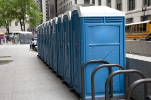 Line of porta potties on a dirt patch